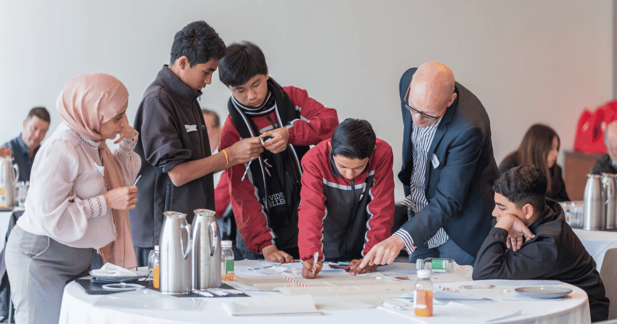 Corporate volunteers work with students